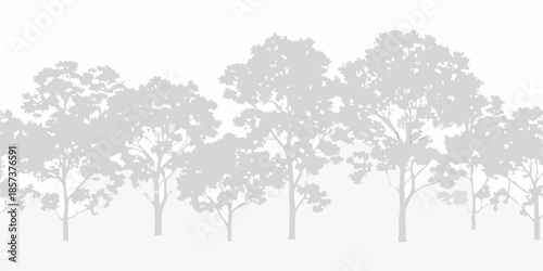 Silhouetted trees against a pale gray background create a peaceful natural scene