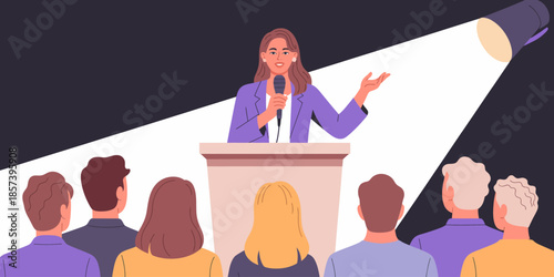 A confident female speaker addresses an eager audience from a podium, with a spotlight illuminating her presence, showcasing effective public speaking skills and engagement.