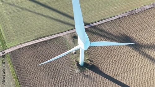 Aerial Wind Turbine Casting Shadow Across Agricultural Fields