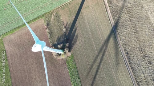 Aerial Wind Turbine Casting Shadow Across Agricultural Fields