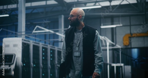 Wallpaper Mural Professional Engineer Walking Through High Tech Facility. IT Supervisor in Dark Vest and Shirt Walks Purposefully Through Large Server Facility. Concept Professional Oversight, Monitoring and Control. Torontodigital.ca