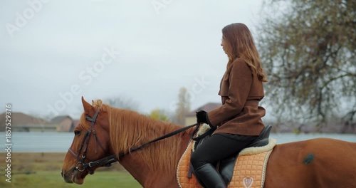 Woman riding horse outdoors in autumn