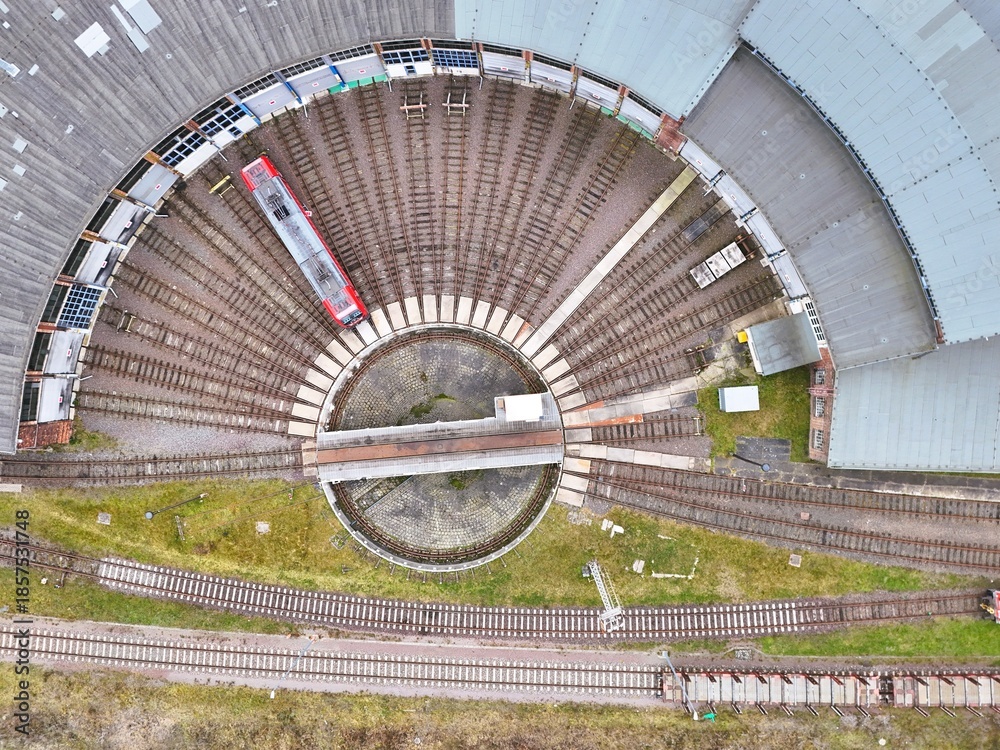 Obraz premium Aerial Top View of Railway Roundhouse with Turntable and Red Train