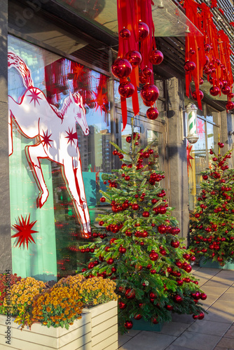 New Year's decorations in front of the cafe entrance. A Christmas tree with red balls. Red ribbons with balls. A drawing of a horse on the window.
