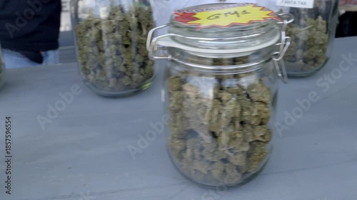 Cannabis buds in glass jars, marijuana, hemp, slow motion