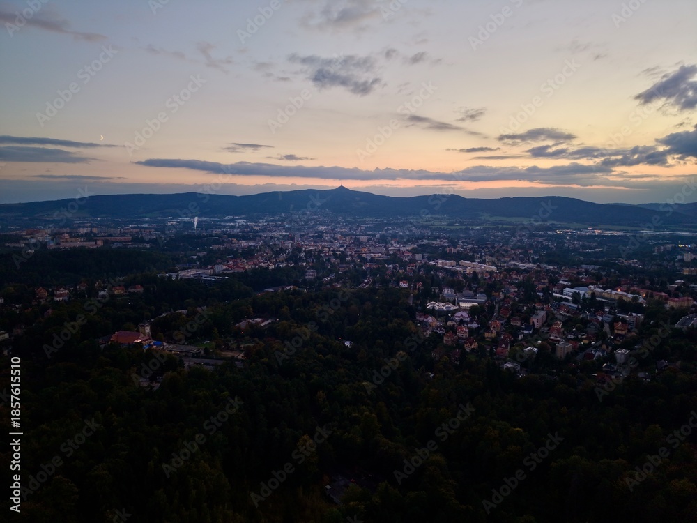 Fototapeta premium Horizon View With Rooftops And Mountains, Hilltop Vista Of Cityscape At Sunset With Distant Mountains