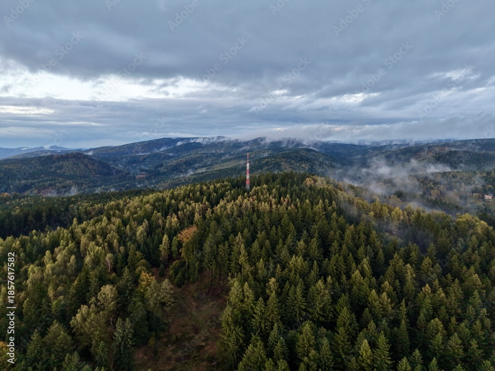 Fototapeta premium Surveillance Drone Captures Mysterious Foggy Skyline With Distant Rolling Hills And Forests