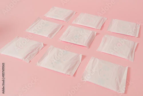 Flat layout of sanitary napkins on pink background. Menstruation cycle, feminine hygiene and protection