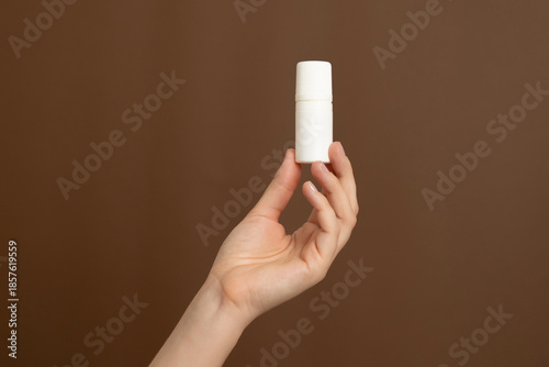 Hand holding blank white cosmetic or medicine roll-on bottle