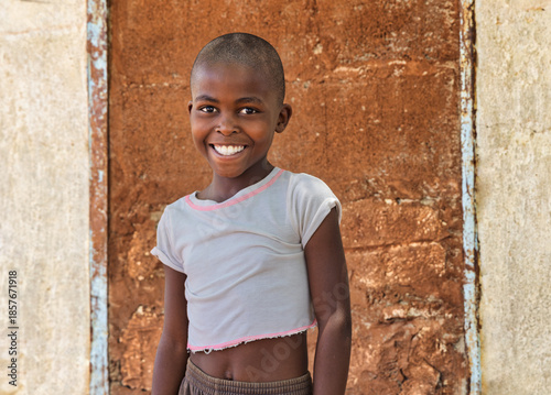 Happy African girl in rural Botswana village. Authentic humanitarian portrait for aid, charity, and development projects. Hope and resilience.