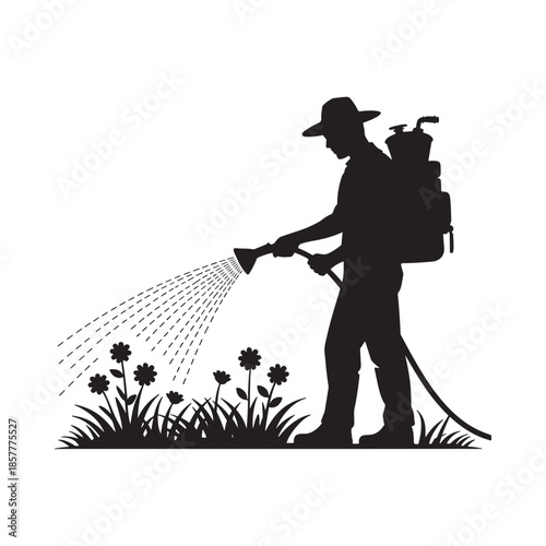 A silhouette of a gardener spraying water onto a small patch of flowering plants