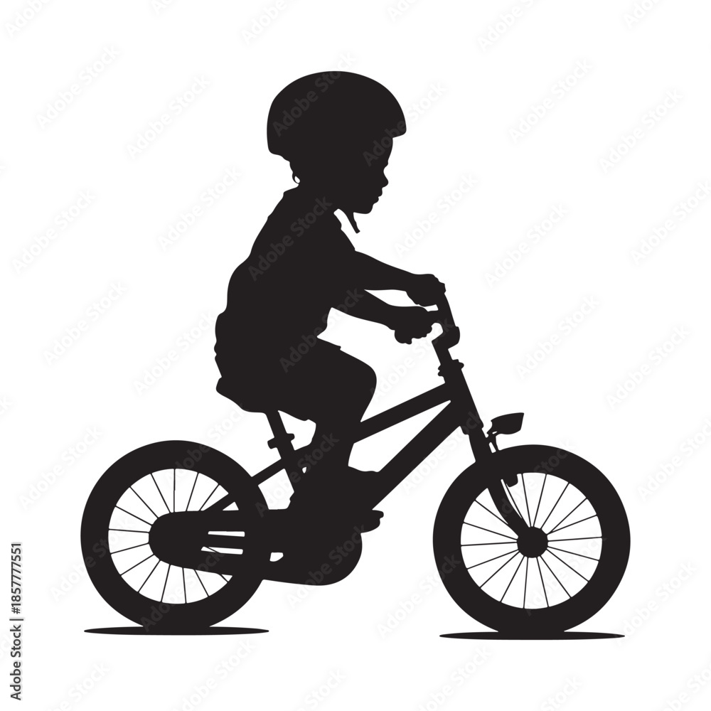 Fototapeta premium A silhouetted depiction of a young child confidently riding a bicycle with a helmet on