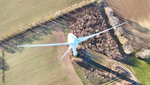 Aerial Wind Turbine Casting Shadow Across Agricultural Fields