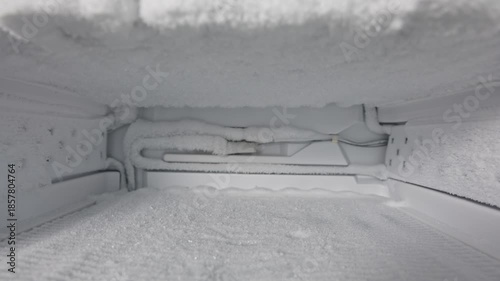Freezer defrosting process showing gradual ice melting and removal revealing clean interior and functional components for efficient operation