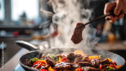 Cooking meat and vegetables in a pan with steam and overhead view
