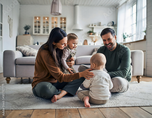 Happy Young Parents Playing With Babies In Cozy Modern Home