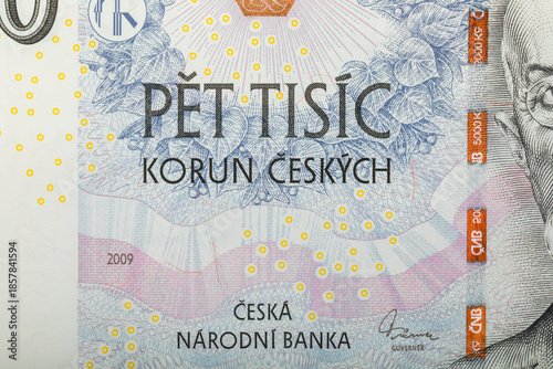 A detailed image showcases a section of a 5000 Czech Korun banknote, featuring the denomination inscription with abstract floral pattern. The banknote was issued in 2009.