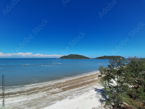 High angle view of a curved bay with low tide sand flats and forested hills