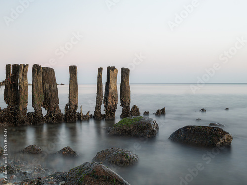 Stones and planks on the beach washed by water