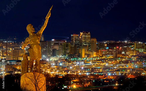 Birmingham city night view with Vulcan monument illuminated above urban landscape