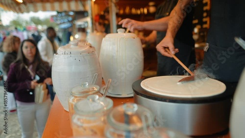 Vendors and onlookers gather to watch pancake preparation process