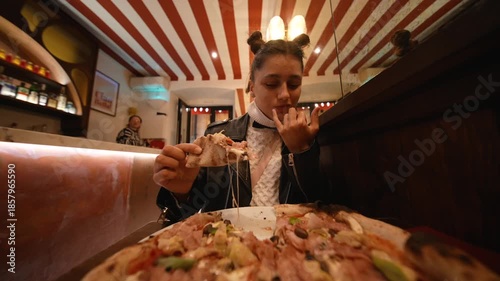 white woman food blogger sampling pizza slice in neon booth