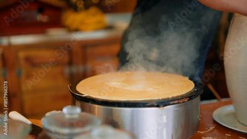 Artful gesture of chocolate suds over steaming pancake creation