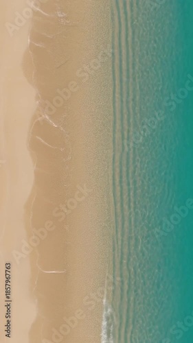 Aerial View of Calm Ocean Waves Rolling onto Sandy Beach During Daylight