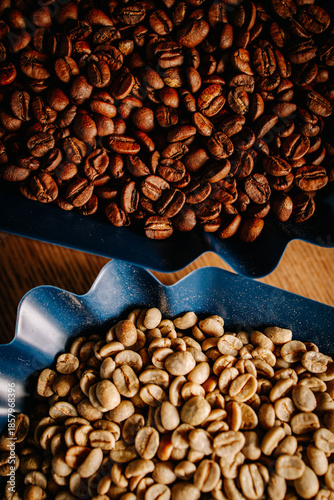 Top view of roasted and green coffee beans in containers. Visual comparison of coffee roasting stages with strong texture and color contrast