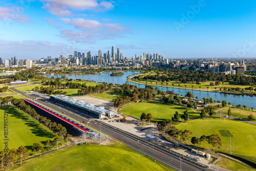 Canvas Print Elevated view of Melbourne's striking city skyline, Albert Park Lake, and the race circuit with grandstands under a bright blue sky