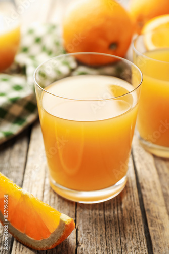 Fresh orange juice and fruits on wooden table, closeup