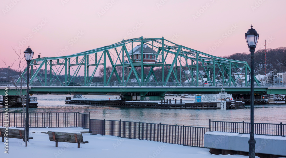Naklejka premium Grand Avenue Swing Bridge with its control house over the Quinnipiac River in Fair Haven, New Haven County, Connecticut, USA at sunset with a pink sky