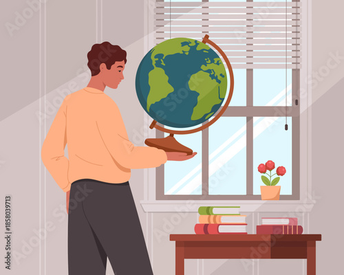 A thoughtful man examines a globe while standing by a bright window, symbolizing curiosity about the world and fostering a sense of exploration and discovery.