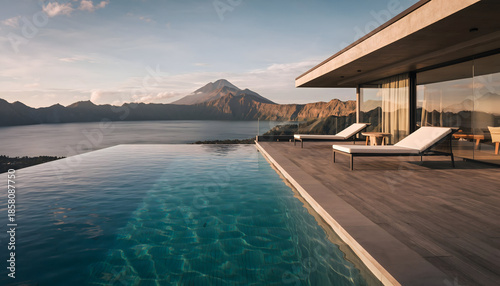 Modern Luxury Villa With Infinity Pool Overlooking A Volcanic Lake And Mountain Landscape At Golden Hour With Sun Loungers And Textured Decking
