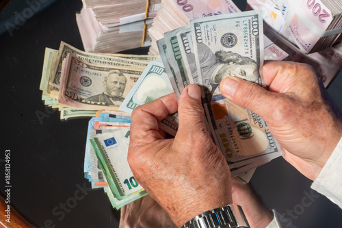 Foto A close-up image of a person counting US dollar bills