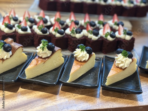 Sliced cheesecake served on plates with whipped cream blueberries and strawberries creating an elegant dessert buffet presentation