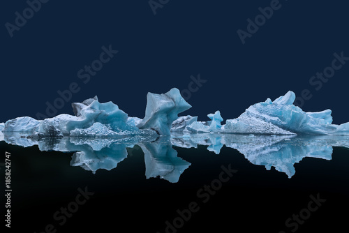 Obraz na płótnie Floating ice blocks on the water surface with reflections against dark blue back