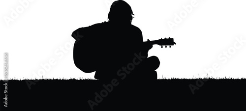 Silhouette of a person playing an acoustic guitar in a serene outdoor setting at dusk or dawn