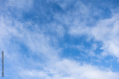 Wispy cirrus clouds in blue sky during calm daytime weather