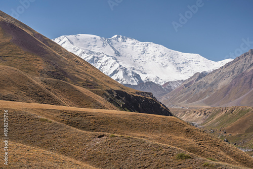 Scenic late summer landscape view of snowcapped Lenin Peak in Trans Alay mountain range, Sary Mogul, Kyrgyzstan