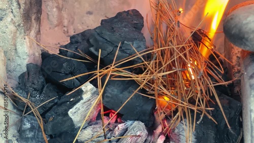 A close-up of charcoal being lit for a barbecue, glowing embers, smoke, and sparks. High quality 4k footage