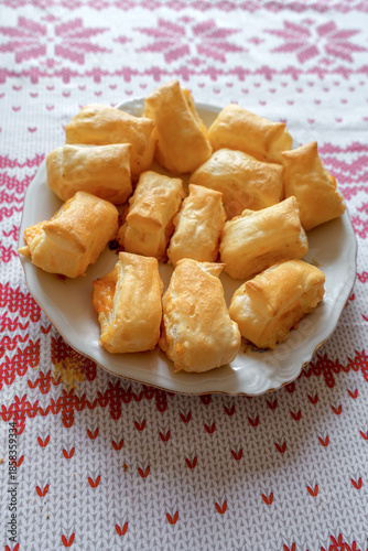 Macro shot of fresh cheese puff pastry buns on a rustic wooden board