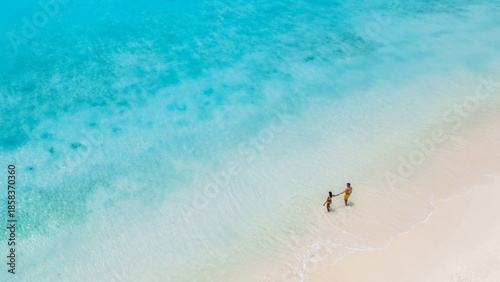 Photos A couple strolls hand in hand along the pristine, white sands of Klein Curacao, surrounded by crystal-clear waters