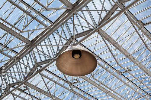 Lamp on the ceiling of a glass roof and blue sky in the background