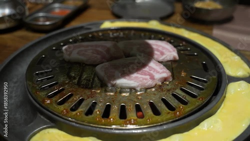 Grilled meat on a charcoal grill pan at Korean BBQ restaurant.