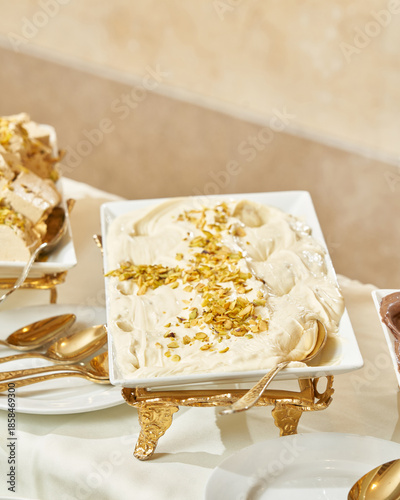 Slika na platnu Creamy white dessert topped with crushed pistachios on display.