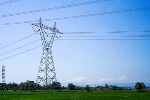 Extra High Voltage Air Line or in Indonesia it called SUTET. High voltage electricity pole with farmland and blue sky in the background.