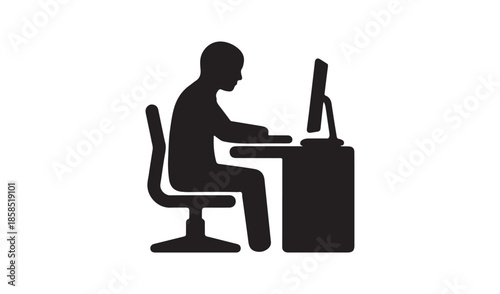Silhouette of a person sitting at a workspace desk and working on a computer monitor