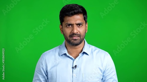 Young Indian Man with Serious Expression on Green Screen Background.