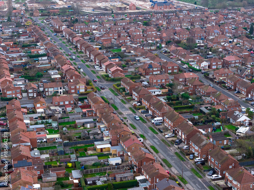 Aerial drone photo of the village of Huntington in the City of York in North Yorkshire England showing rows of typical British houses and housing estates with roads, streets and gardens from above